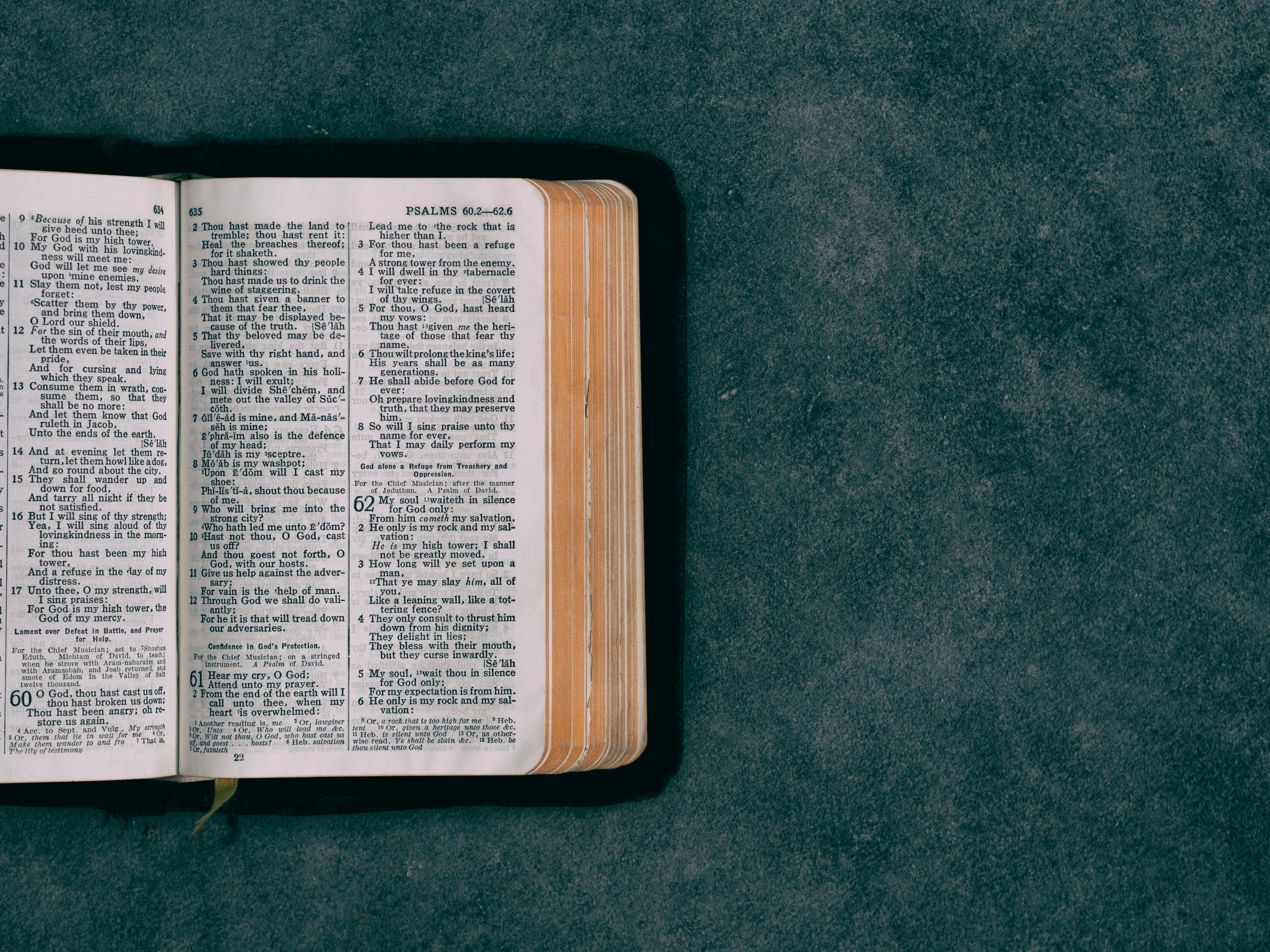 An open Bible on a dark textured surface